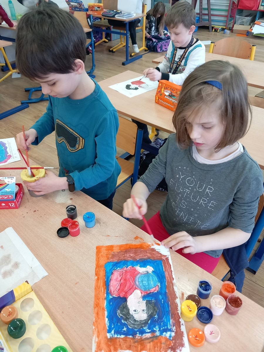 Dzieci maluja farbami pracę  plastyczna.