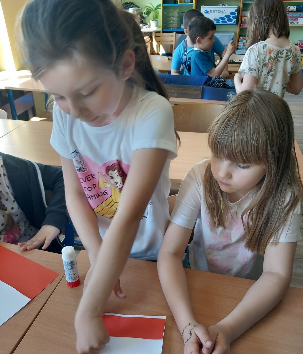 Dziewczynki wykonują flagę Polski z papieru