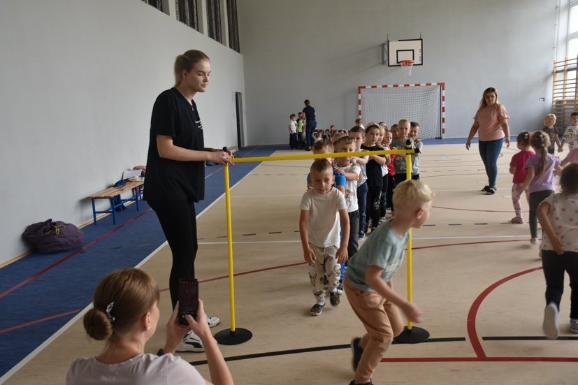 Przedszkolaki biorą udział w zabawach sportowych na sali gimnastycznej