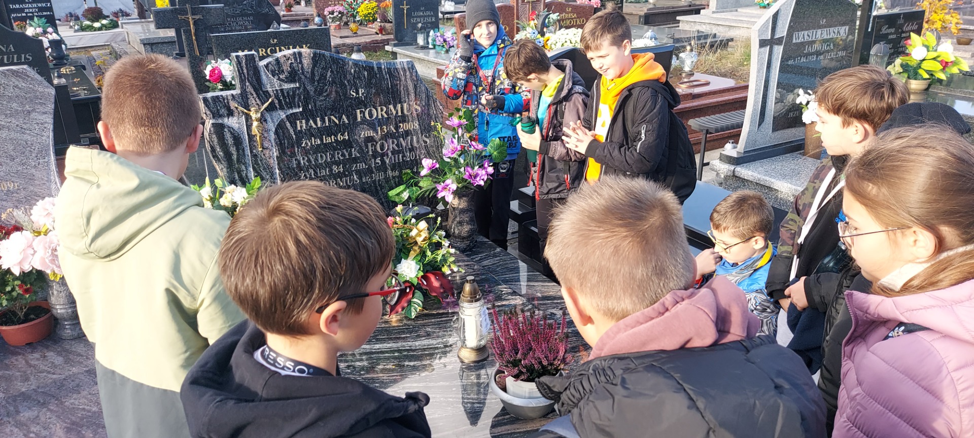 Akcja "Dzieli nas tylko czas..." opiekunowie z uczniami Szkoły Podstawowej Nr 2 im. M. Kopernika w Olecku podczas wizyty przy grobach i modlitwie