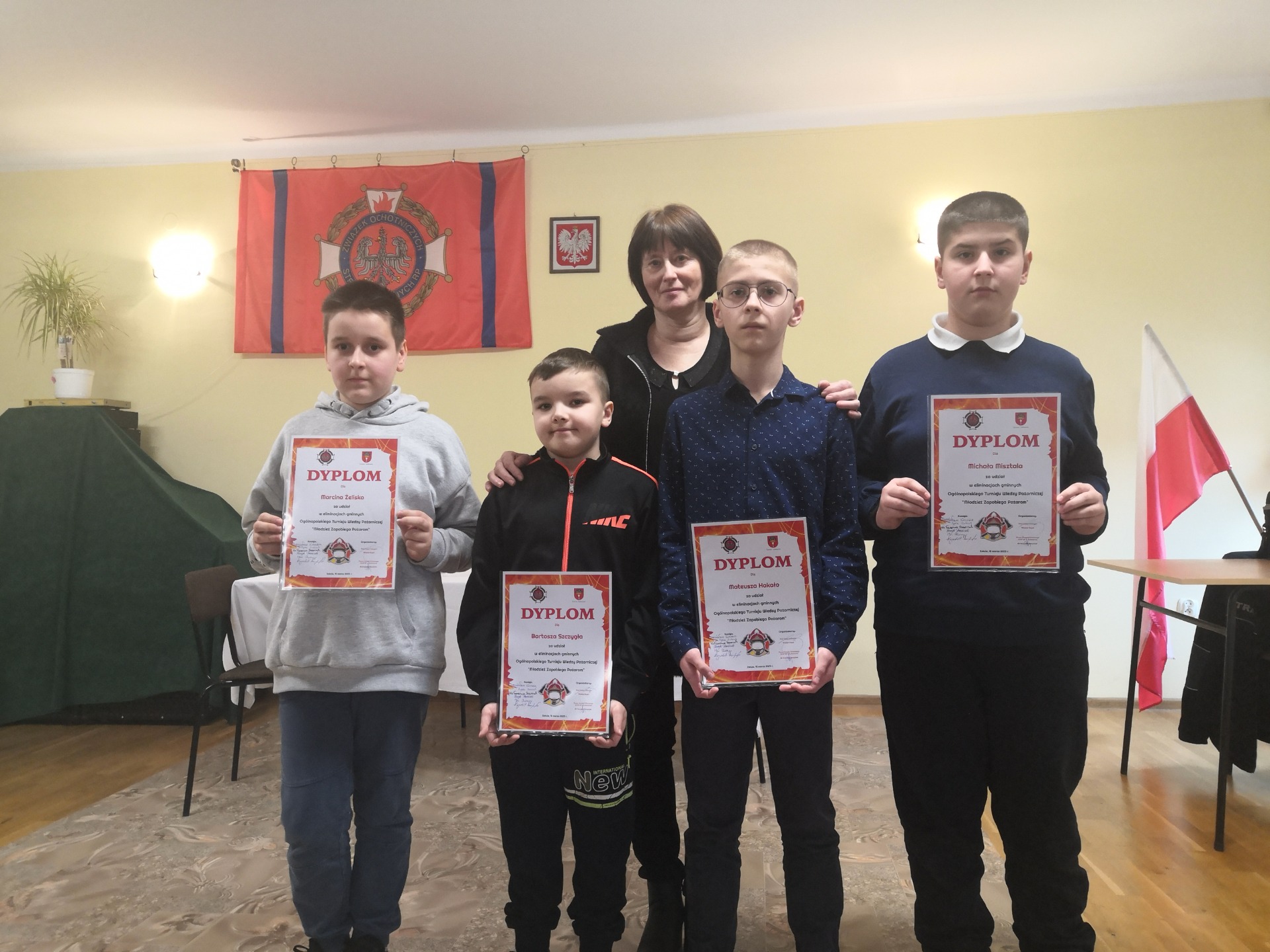 Uczestnicy Ogólnopolskiego Turnieju Wiedzy Pożarniczej „Młodzież Zapobiega Pożarom” z dyplomami i opiekunem