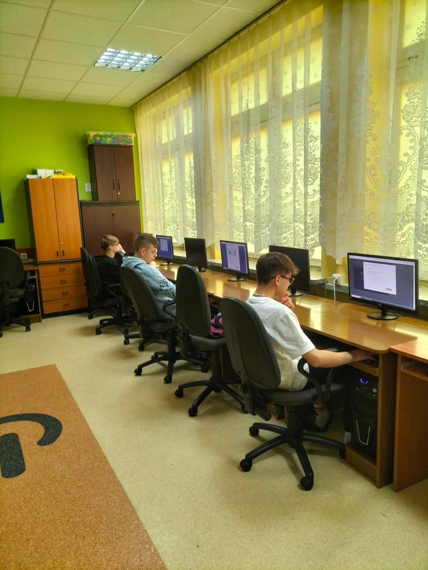 Uczniowie w pracowni komputerowej rozwiązują test konkursowy online.