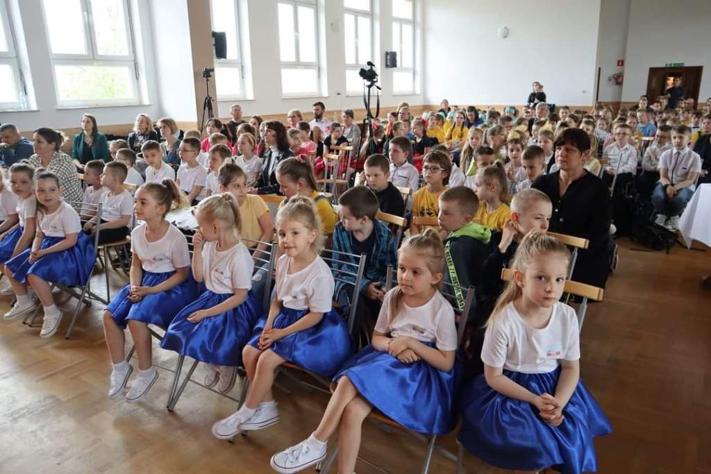 Na zdjęciu drugim na widowni siedzą uczestnicy Gminnego Przeglądu Dziecięcych Zespołów Tanecznych wraz z opiekunami.