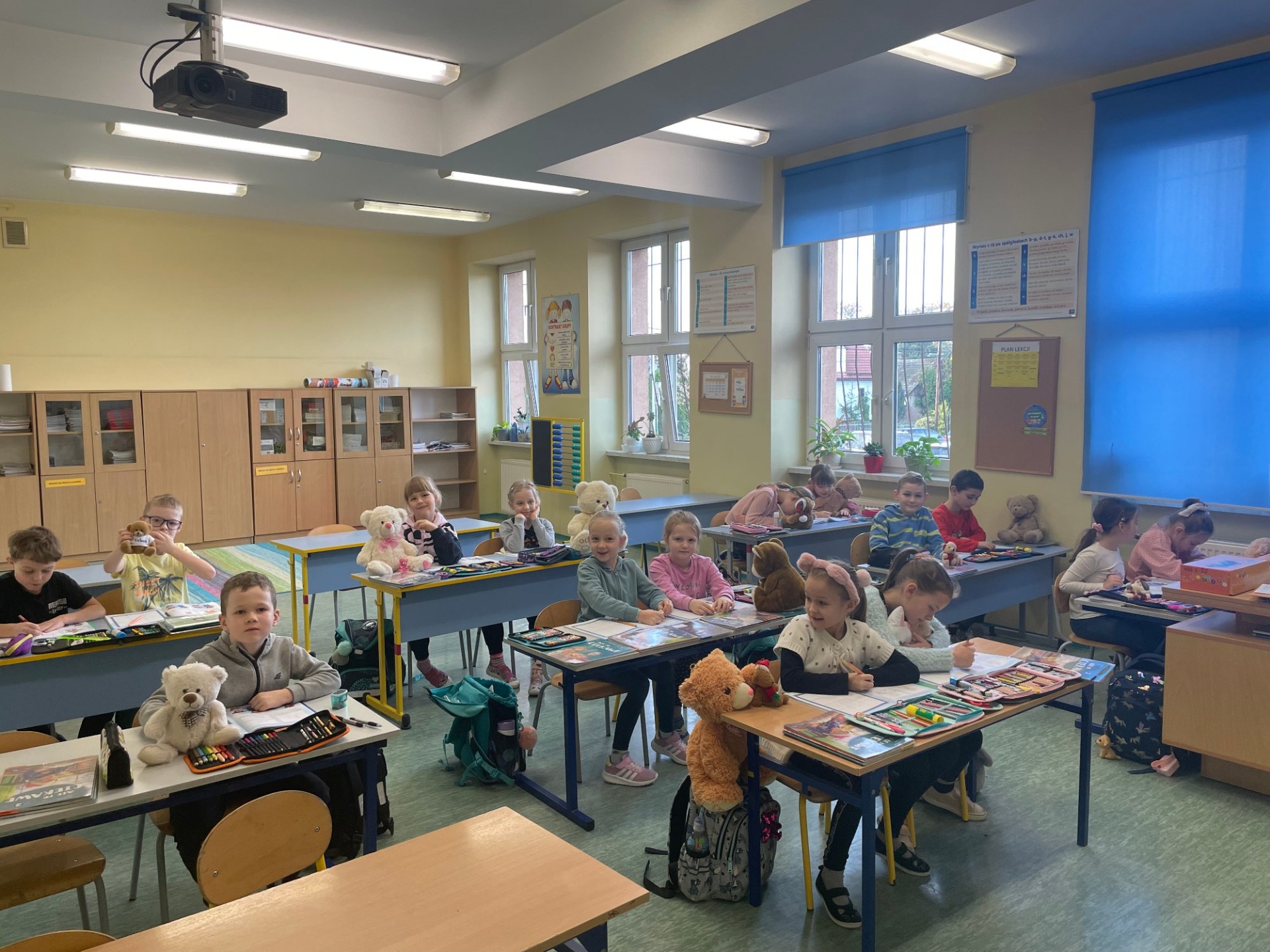 Pluszowe misie siedzą razem z dziećmi na lekcjach w ławkach