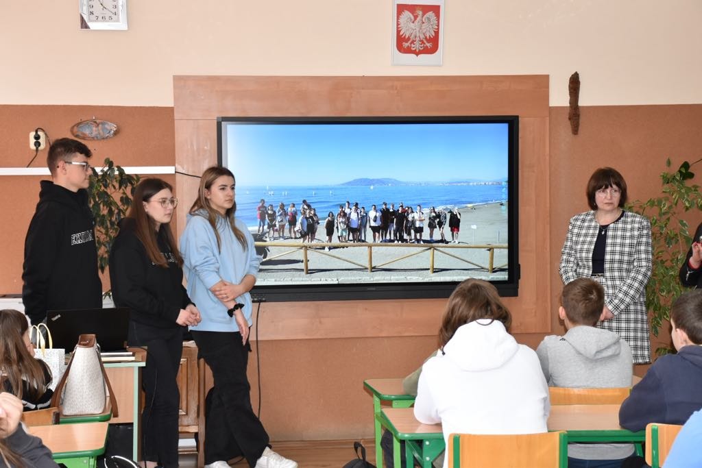 Uczniowie i nauczyciele "Ekonomika" przy monitorze interaktywnym prezentują ofertę edukacyjną szkoły.