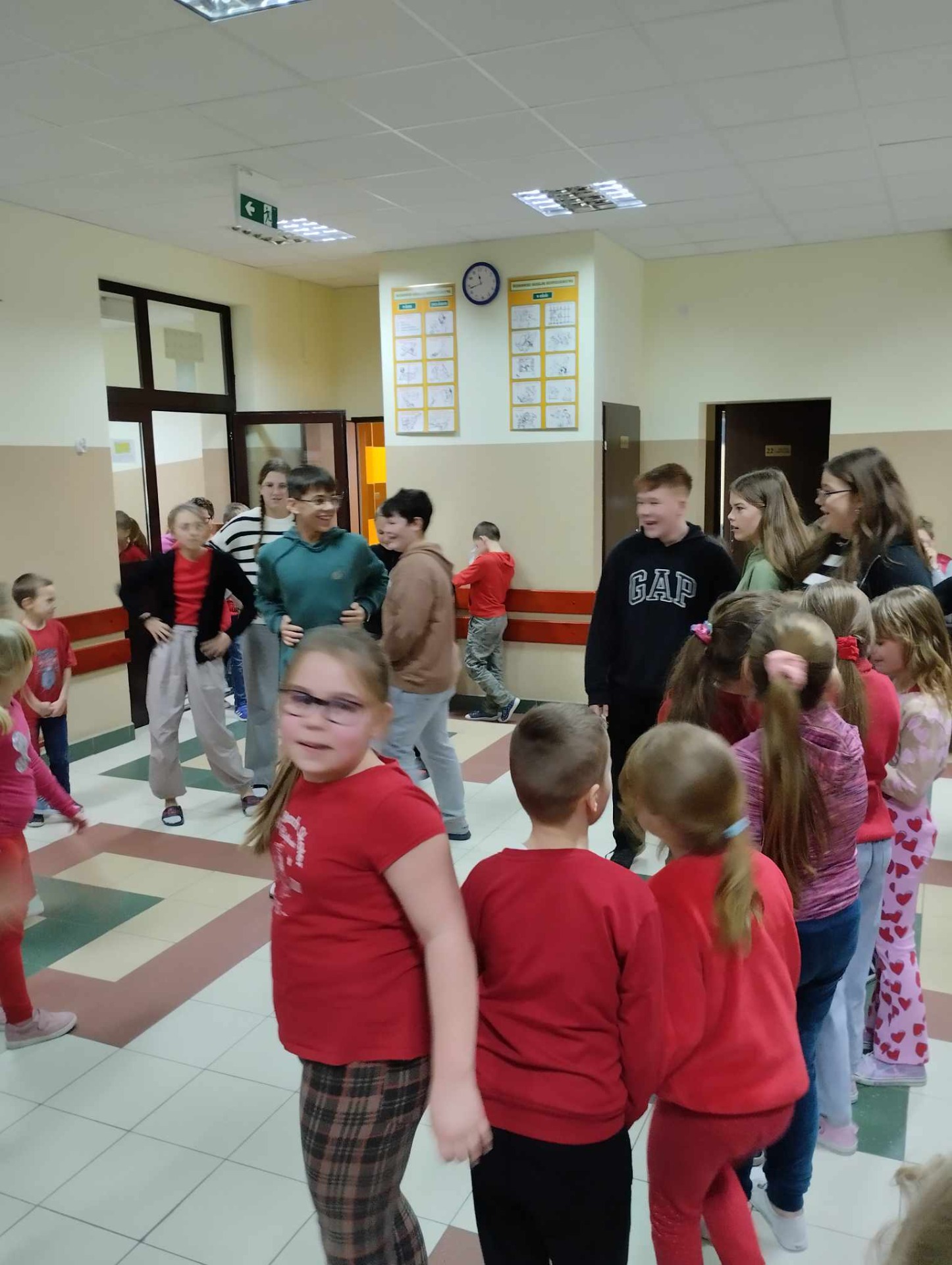 Uczniowie tańczą na szkolnym korytarzu.
