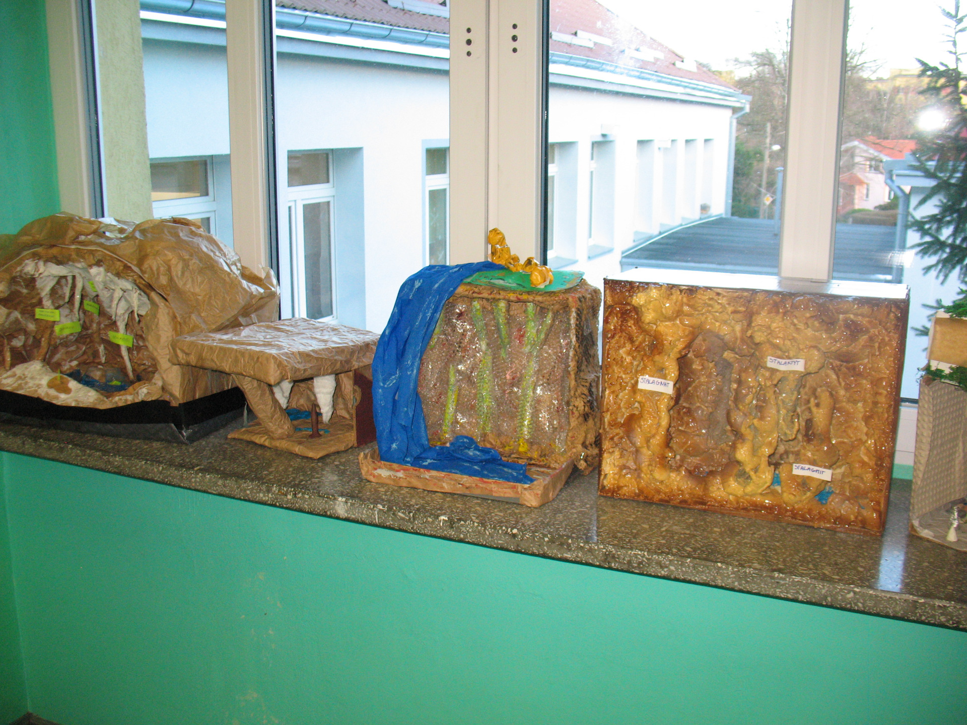 Modele jaskiń zaprezentowane na parapecie na szkolnym korytarzu.